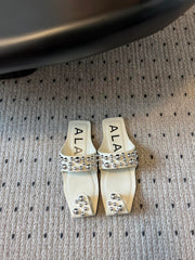 ALAIA FOLDED FLAT MULES WITH SPHERES ON WHITE CALFSKIN