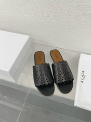 ALAIA VIENNE FLAT MULES IN BLACK LAMBSKIN