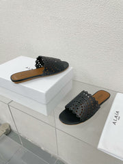 ALAIA VIENNE FLAT MULES IN BLACK LAMBSKIN