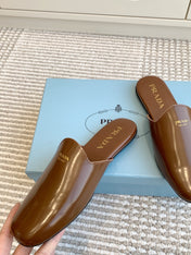 MULES IN BROWN GLOSSY SHEEPSKIN GOLD LETTERING LOGO