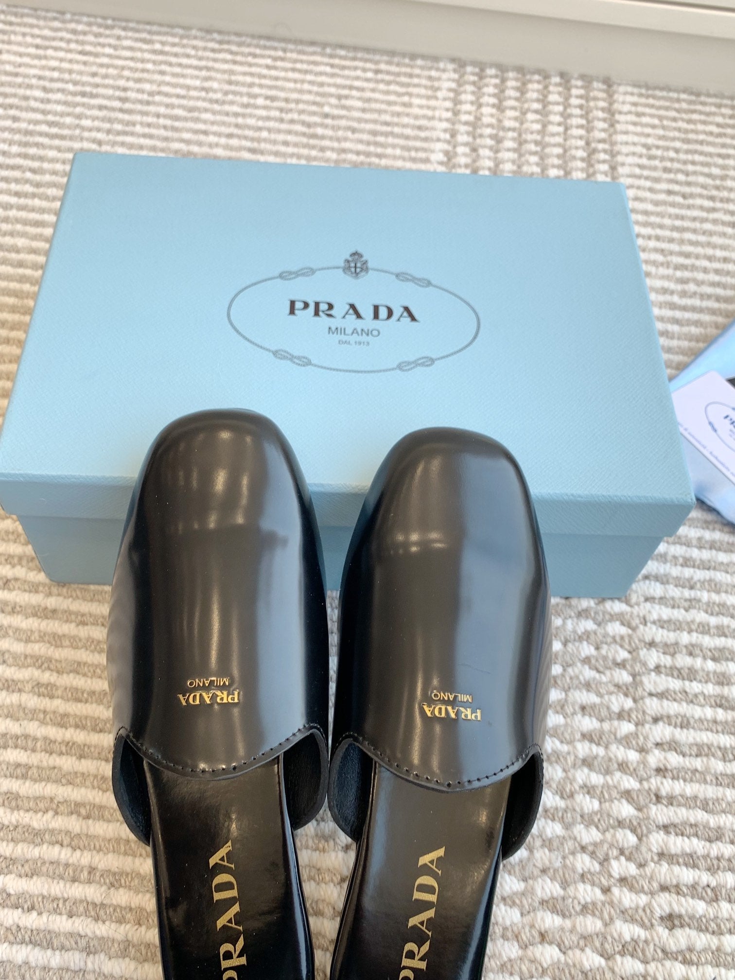 MULES IN BLACK GLOSSY SHEEPSKIN GOLD LETTERING LOGO