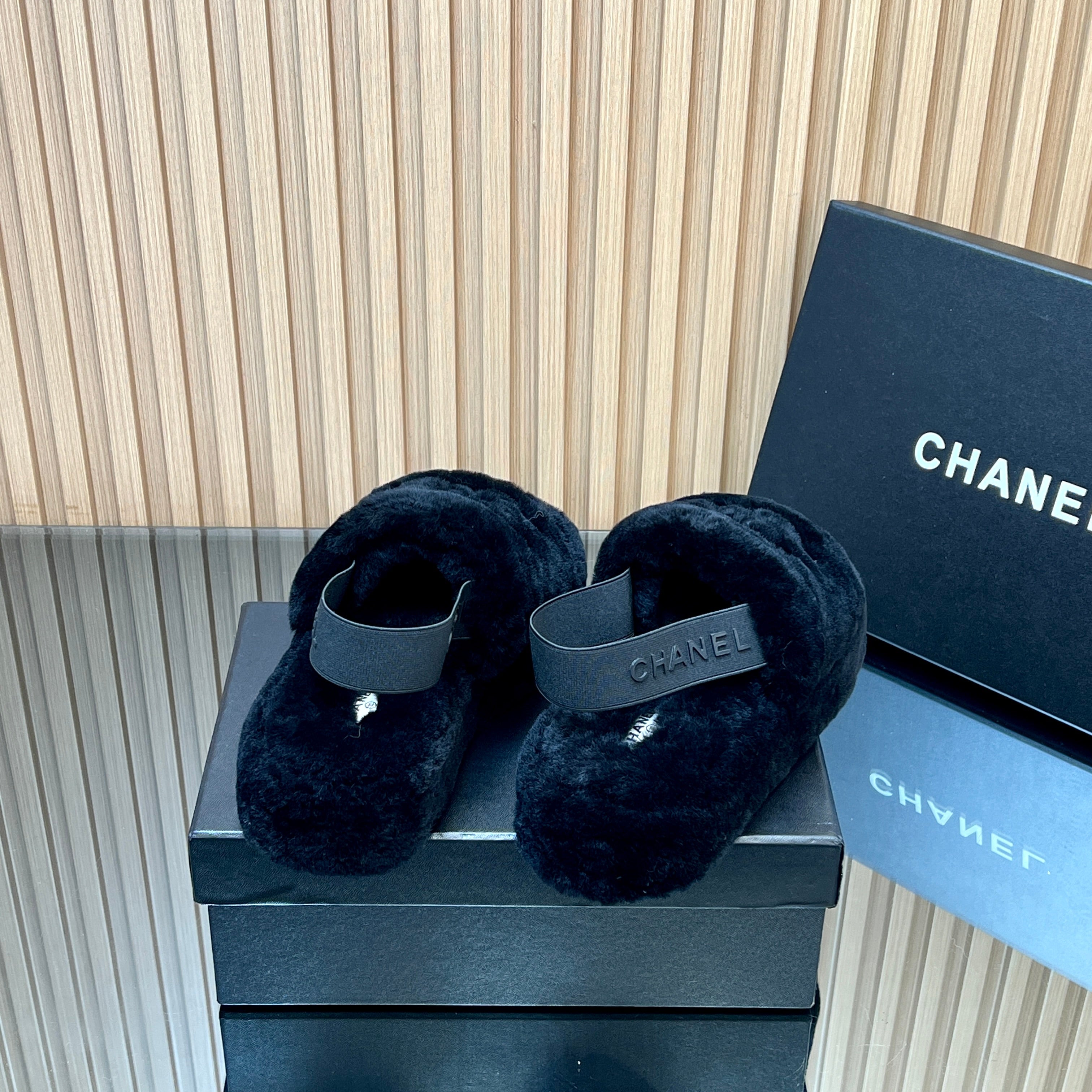 CHANEL 25S THICK-SOLED FURRY SLIPPERS WITH ELASTIC STRAPS IN BLACK FUR