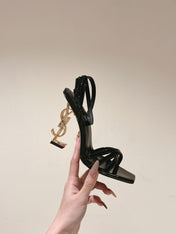 YSL 25S HIGH-HEEL SANDALS 100 MM IN BLACK GLOSSY LAMBSKIN WITH YSL LOGO HEEL DESIGN IN GOLD