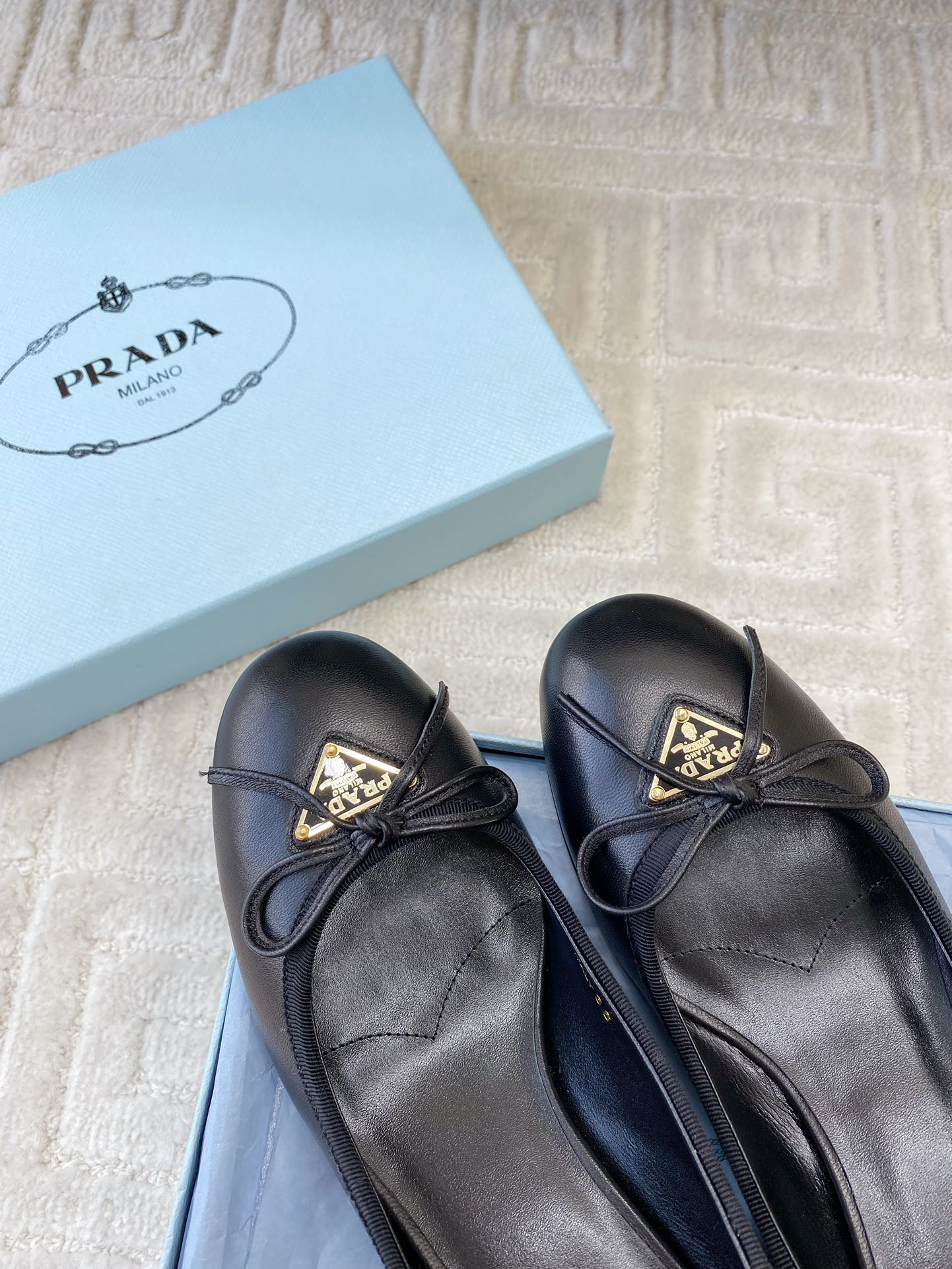 BALLERINA PUMPS WITH TRIANGLE LOGO AND BOW IN BLACK CALFSKIN