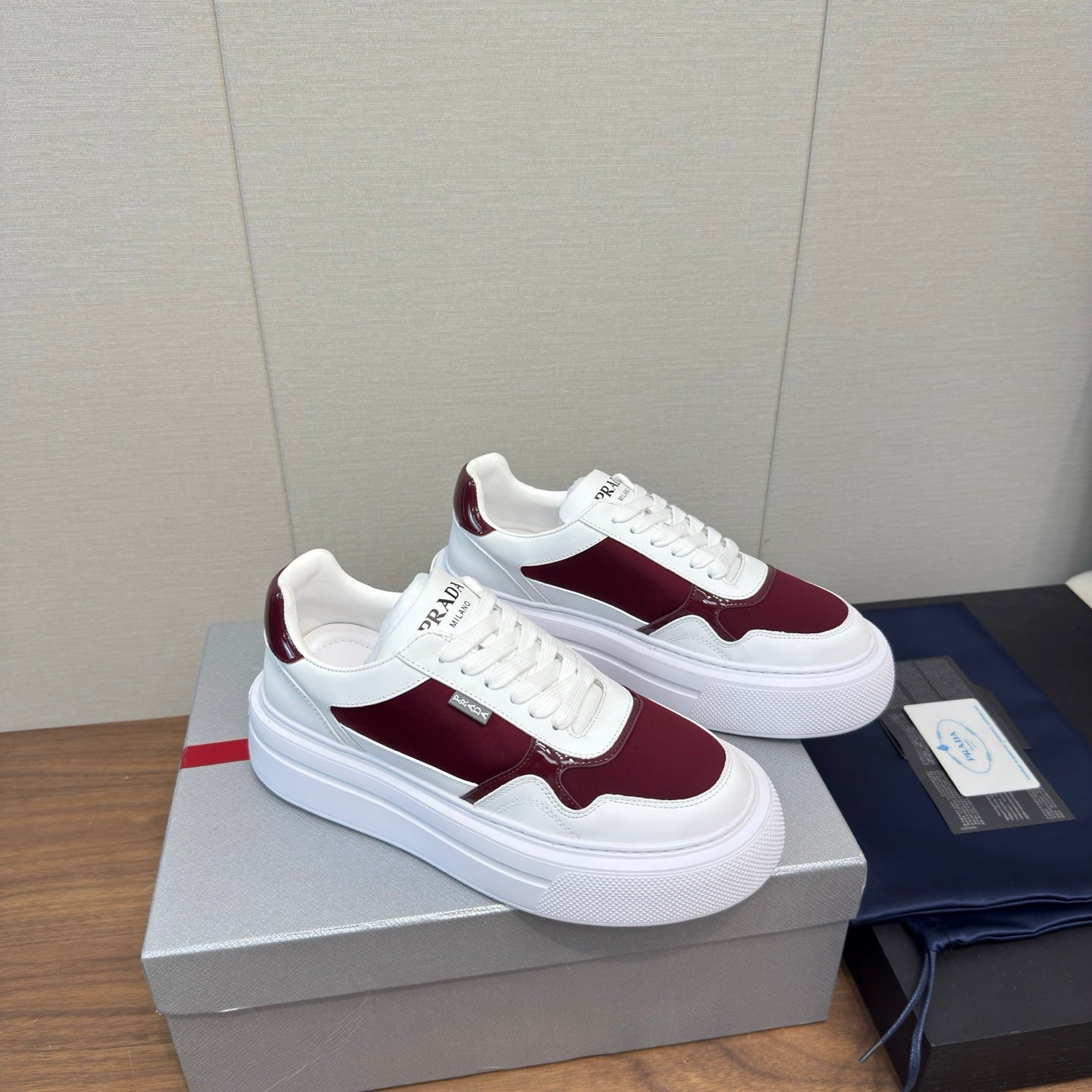 PRADA 25S DOWNTOWN BOLD SNEAKERS 45MM IN WHITE AND BURGUNDY CALFSKIN
