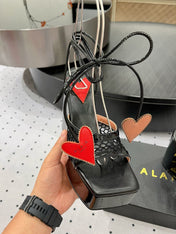 ALAIA BANQUET WEDGE SANDALS IN BLACK LAMBSKIN WITH RED HEART