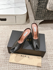 ALAIA SPIKE JEWEL MULES IN BLACK CALFSKIN